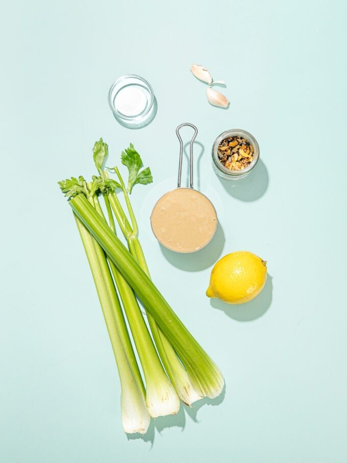celery ribs, a lemon, garlic and bowls of tahini, salt and everything bagel seasoning