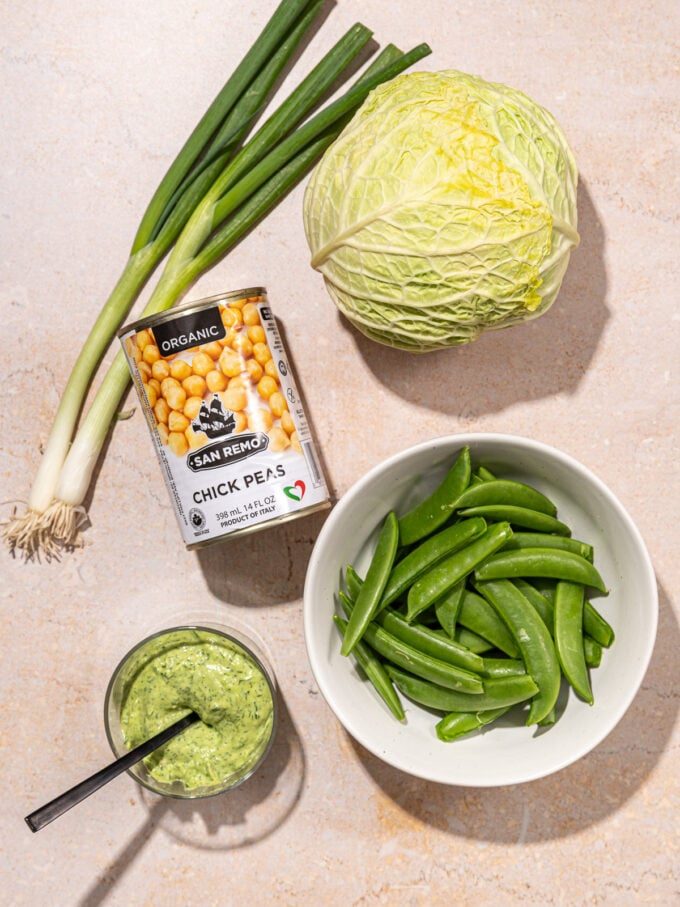 can of chickpeas, savoy cabbage, bowl of snap peas plus green goddess dressing
