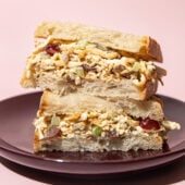 stacked halves of a tofu "chicken" salad sandwich on a purple plate