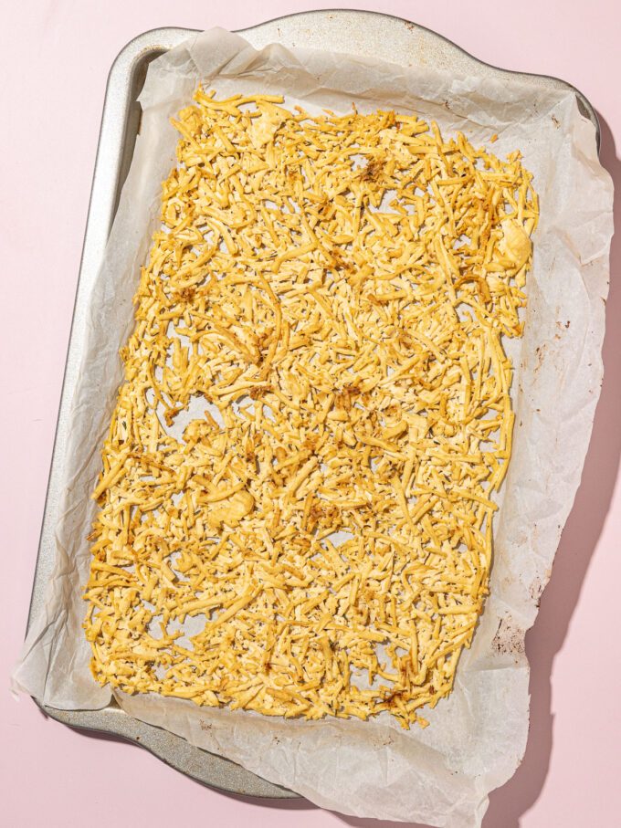 parchment lined baking sheet covered in baked shredded tofu