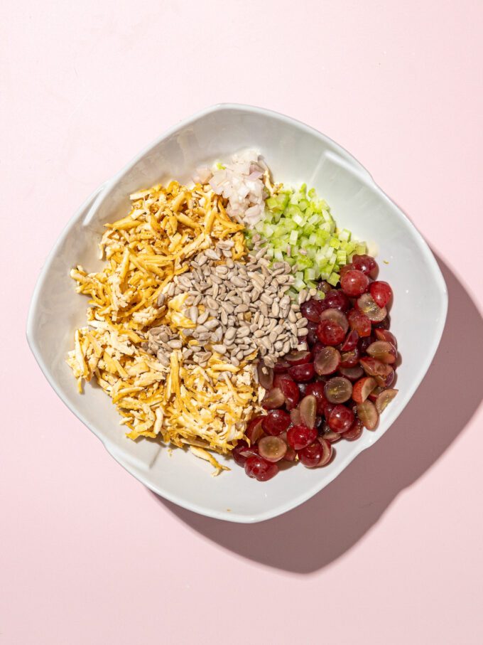 bowl of shredded baked tofu, sunflower seeds, diced celery, sliced red grapes and mayo dressing