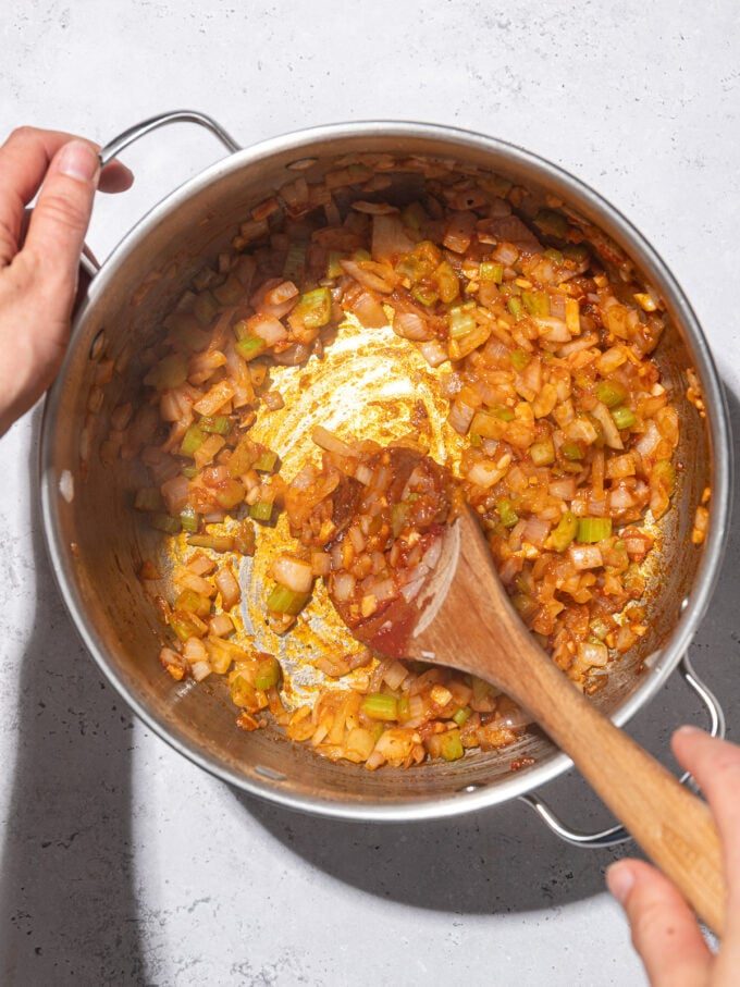 mixing better than bouillon into diced veggies in soup pot with wooden spoon